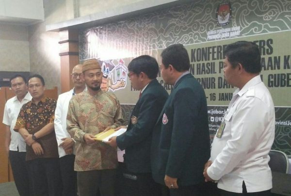 Komisioner KPU Jabar Endun Abdul Haq (berpeci) menerima berkas pemeriksaan kesehatan paslon Gubernur dan Wagub dari Ketua Tim Rikes Bapaslon Gubernur Jabar dr Eka Mulyana, di Aula Setia Permana Kantor KPU Jabar, Jl. Garut No. 11 Bandung, Senin (15/11/18). by KPU