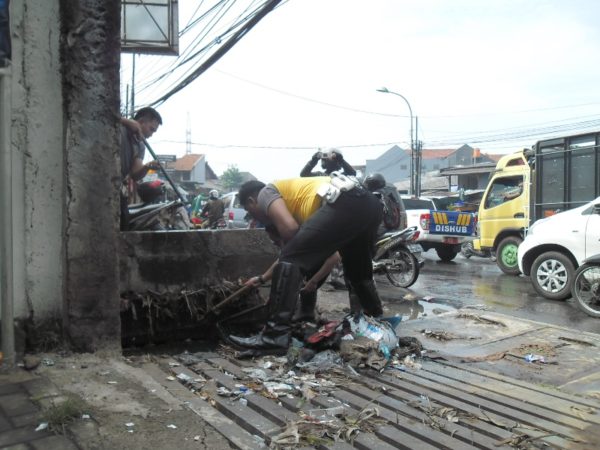 Personil Satlantas Polres Bandung bersihkan saluran air di Jalan Raya Cinunuk, Cileunyi, Jumat (3/3). by iwa/bbcom