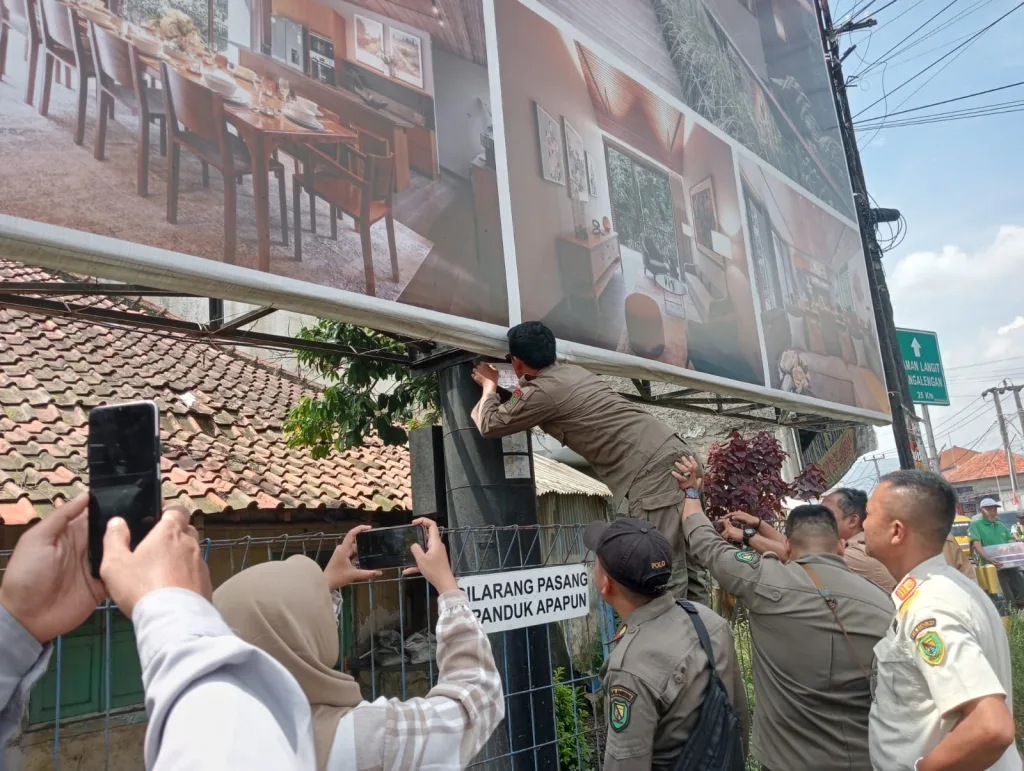 Tak Berizin, Satpol PP Kab Bandung Pasang Stiker Peringatan di Puluhan Tiang Reklame